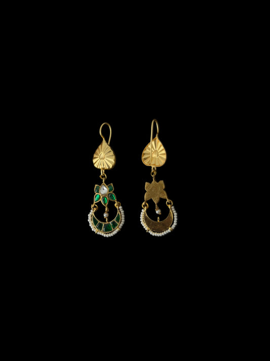 Pair of gold earrings with gemstones on a black background