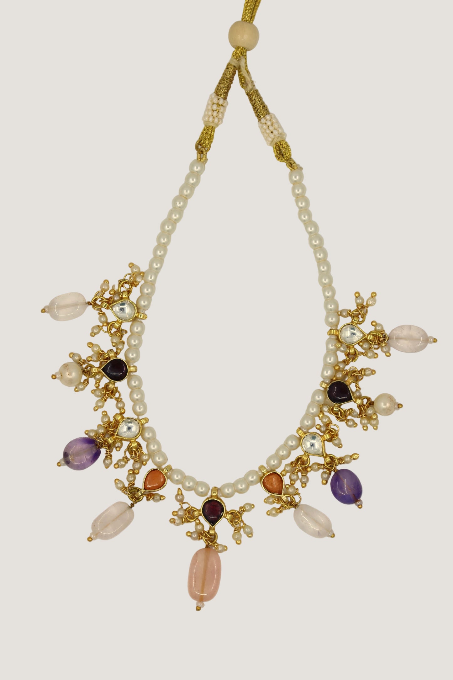 Necklace with pearls and multicolored beads on a beige background