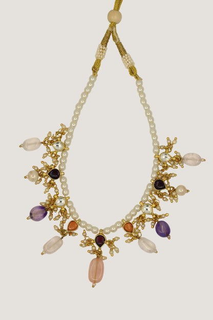 Necklace with pearls and multicolored beads on a beige background