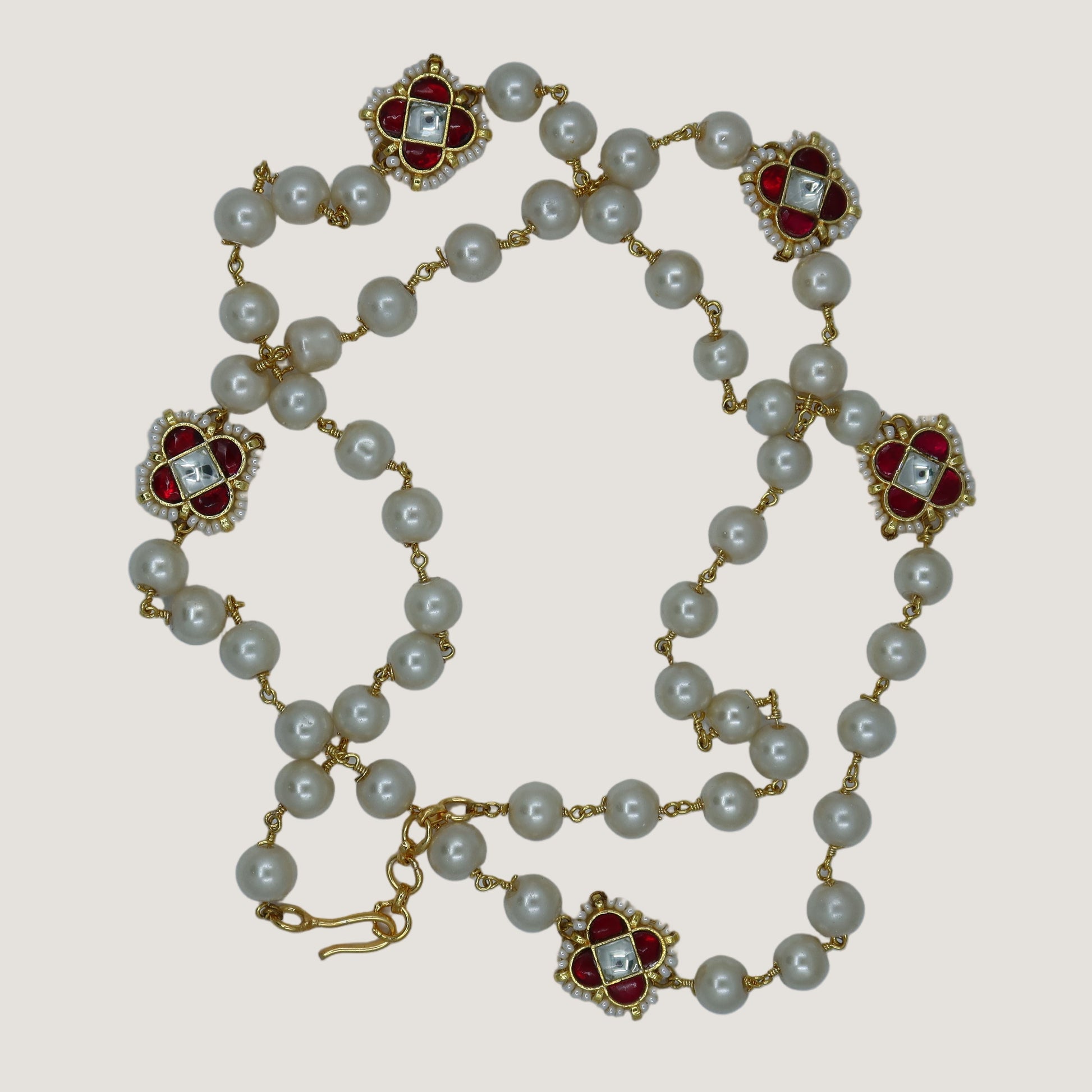 Pearl necklace with floral clasp on a light gray background