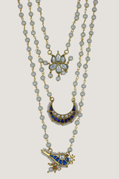 Gold necklace with decorative pendants on a light gray background