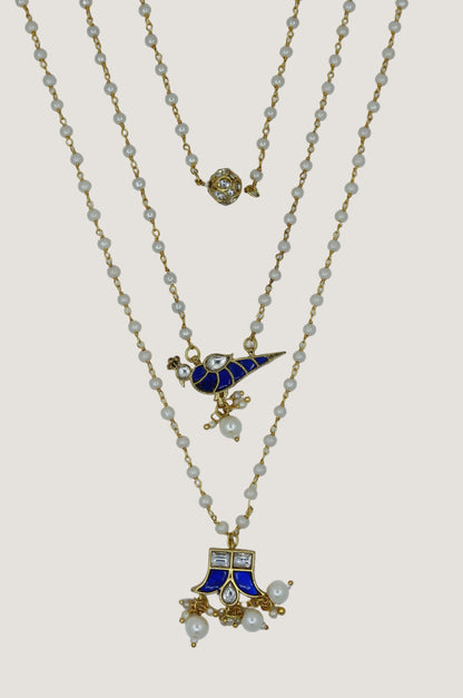 Three gold necklaces with blue and white pendants on a white background
