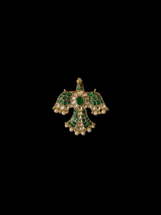 Gold and green brooch on a black background